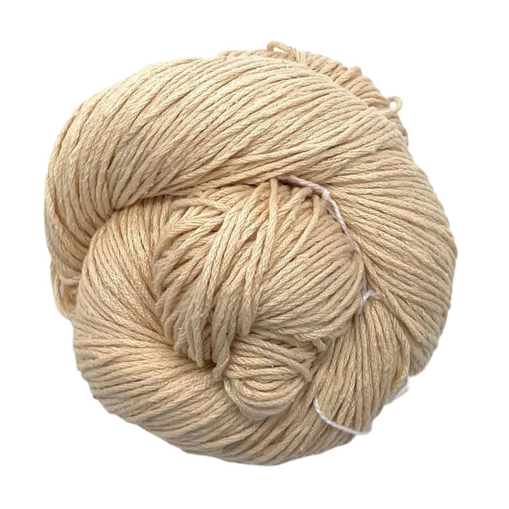 A skein of mulberry silk fingering yarn in the colorway 'bone' sitting on a white background.