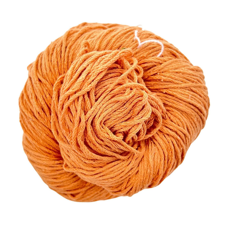 A skein of Mulberry silk fingering yarn in the colorway 'peach' on a white background.