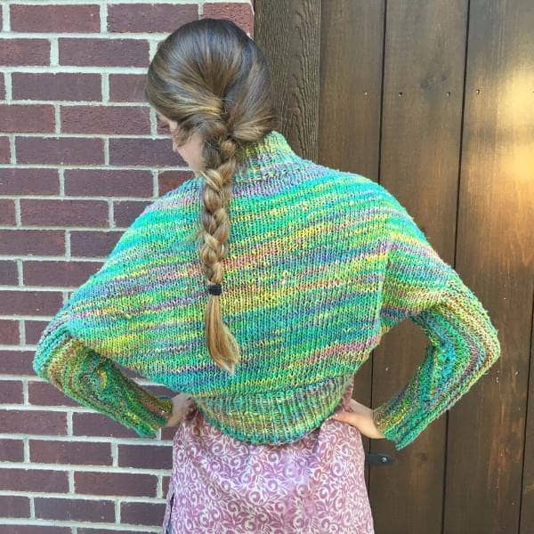 back of a woman wearing a colorful green and yellow Shrug