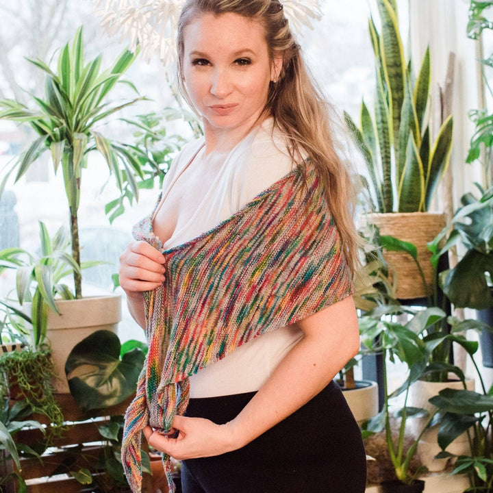 Model wearing california skied neon pop shawl with potted greenery in the background.