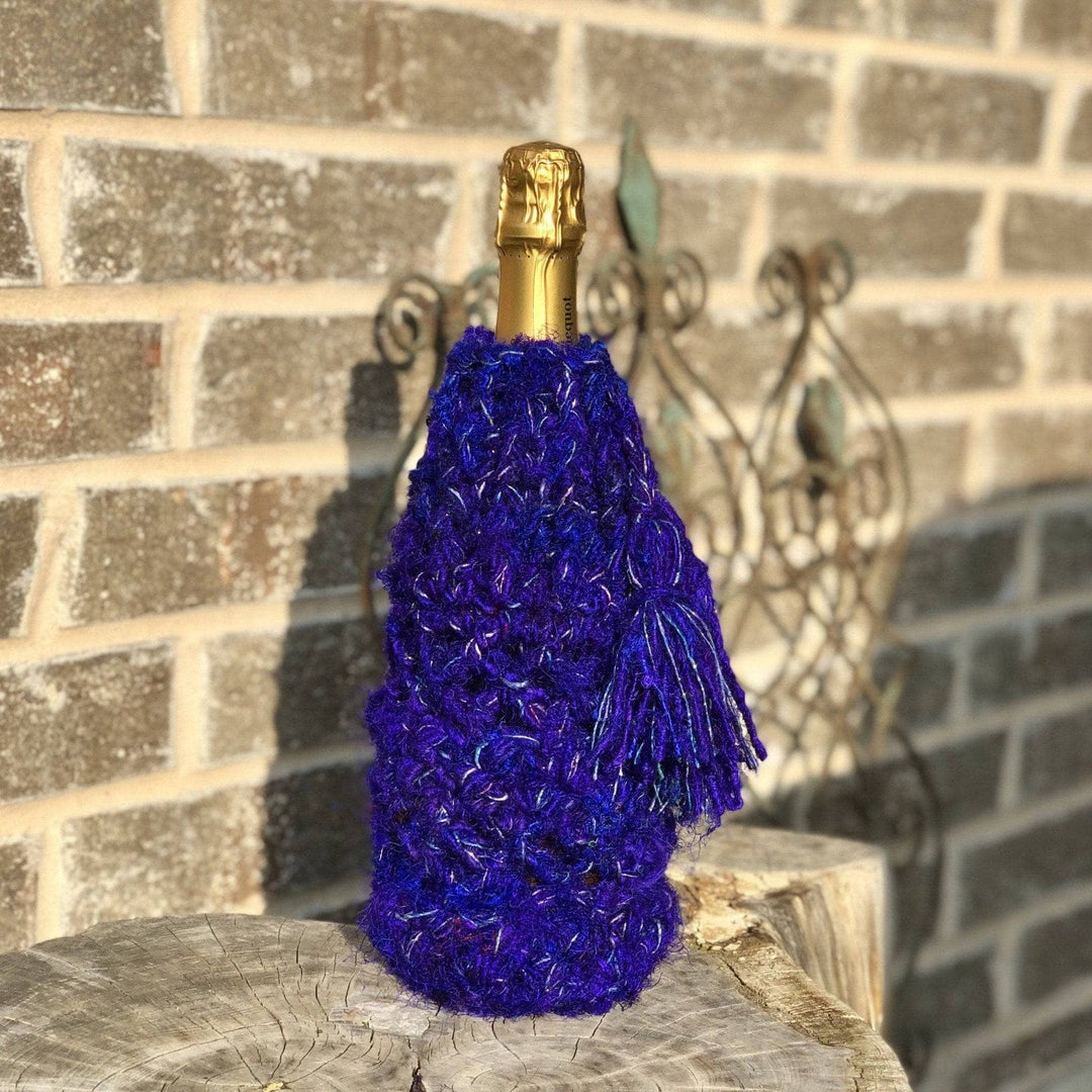 Champagne bottle wrapped in recycled silk bottle cover with brick background