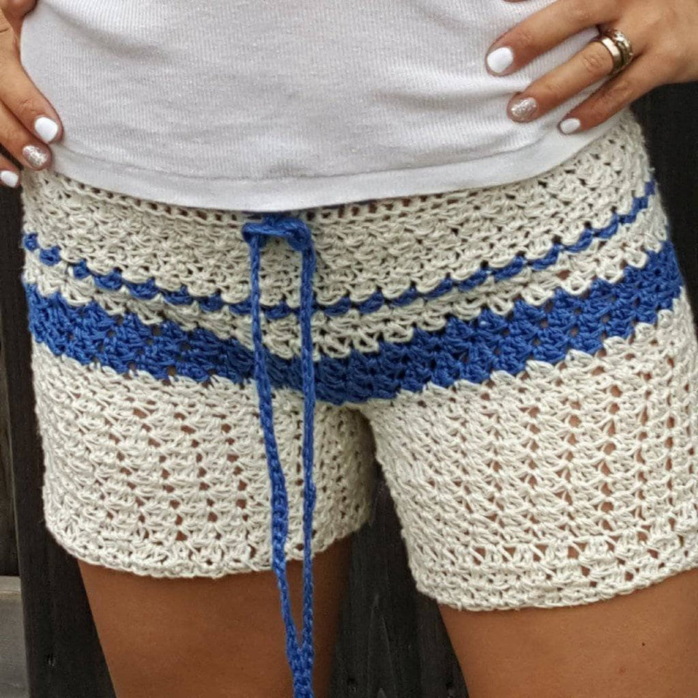 close up of a woman wearing white and blue crochet shorts 