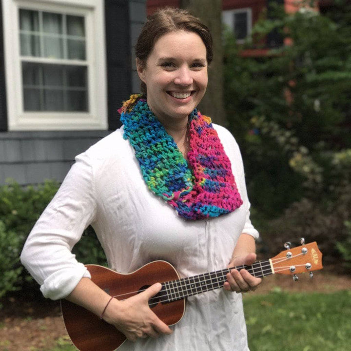 woman holding a banjo wearing a colorful scarf
