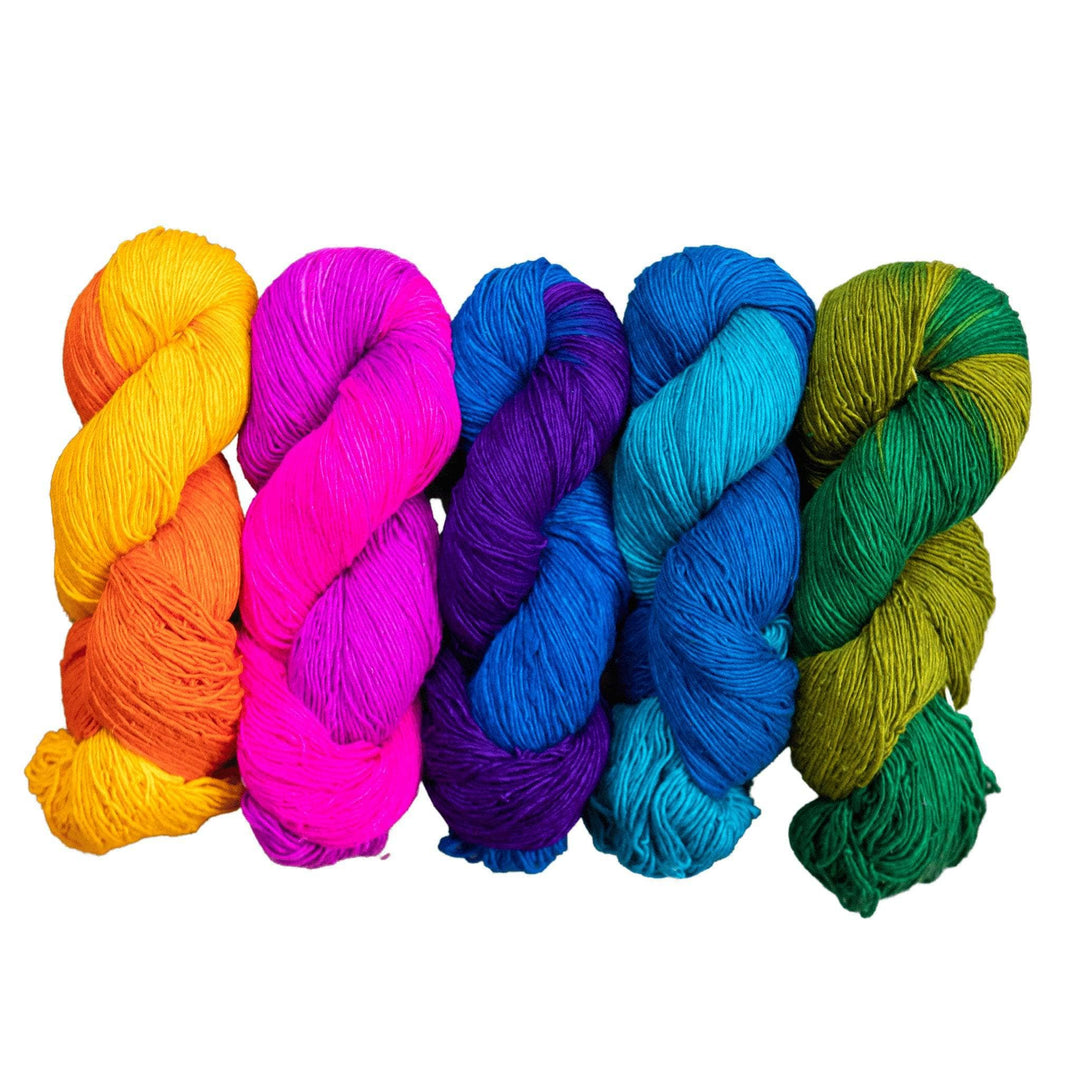 5 skeins sport weight silk in the colorway rainbow in front of a white background. From left to right are orange, pink, dark blue, light blue, and green.