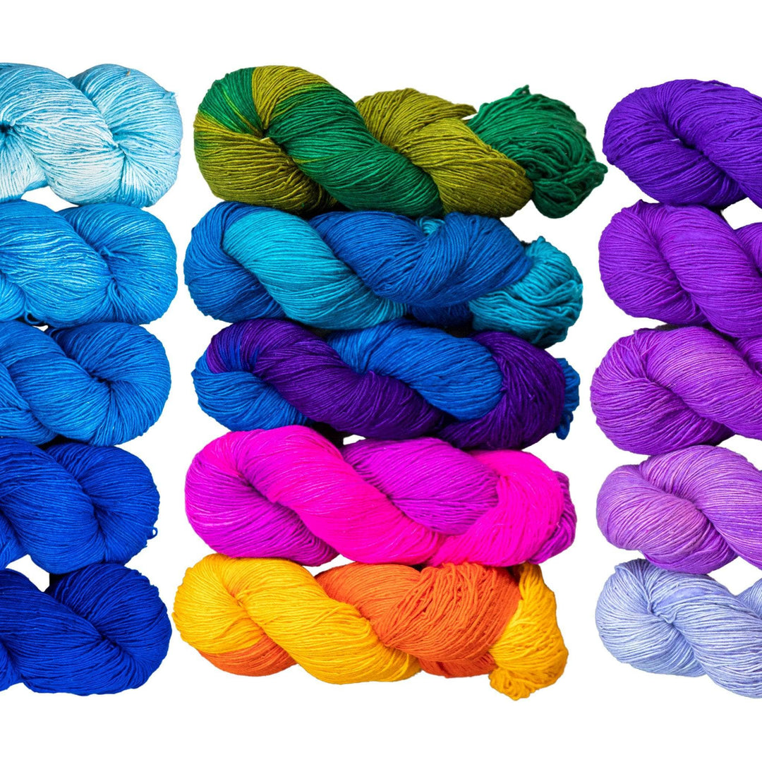 ombre sport weight silk exploration multi pack in front of a white background. Left to right, blue colorway, rainbow colorway, purple colorway.