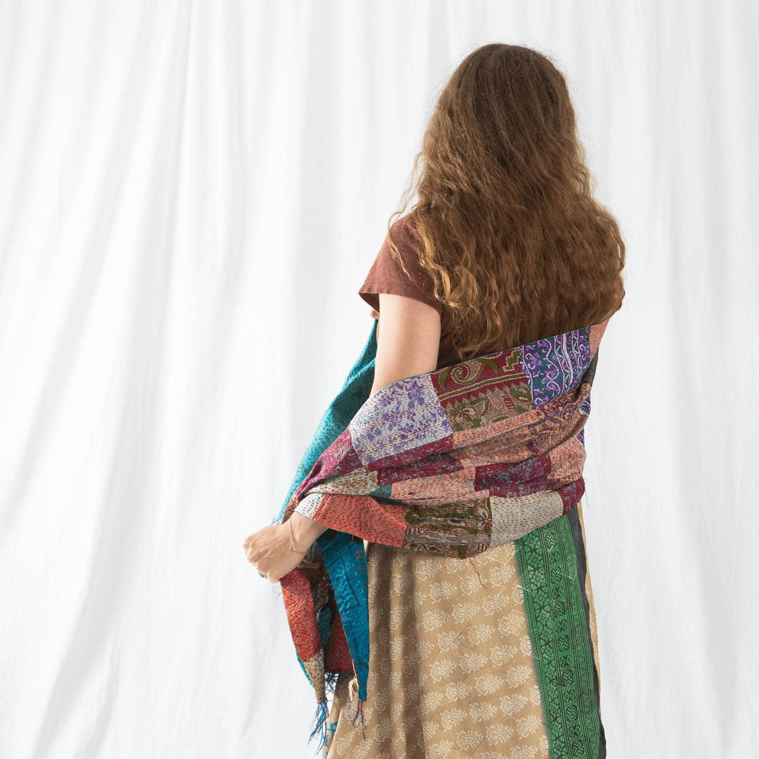 Model Nicole wrapped in neutral multicolor kantha scarf in front of a white background.