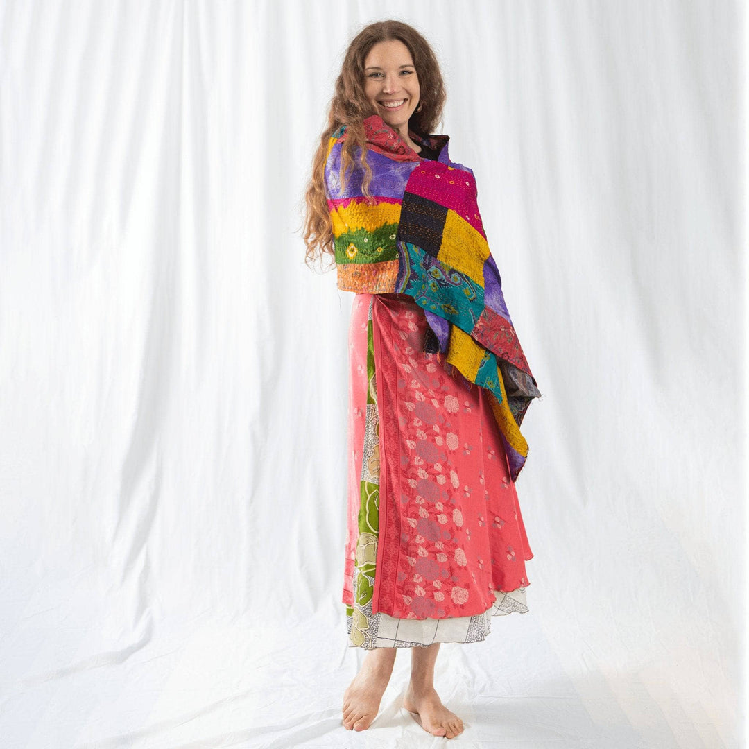 Founder Nicole wrapped in vibrant multicolored kantha scarf in front of a white background.