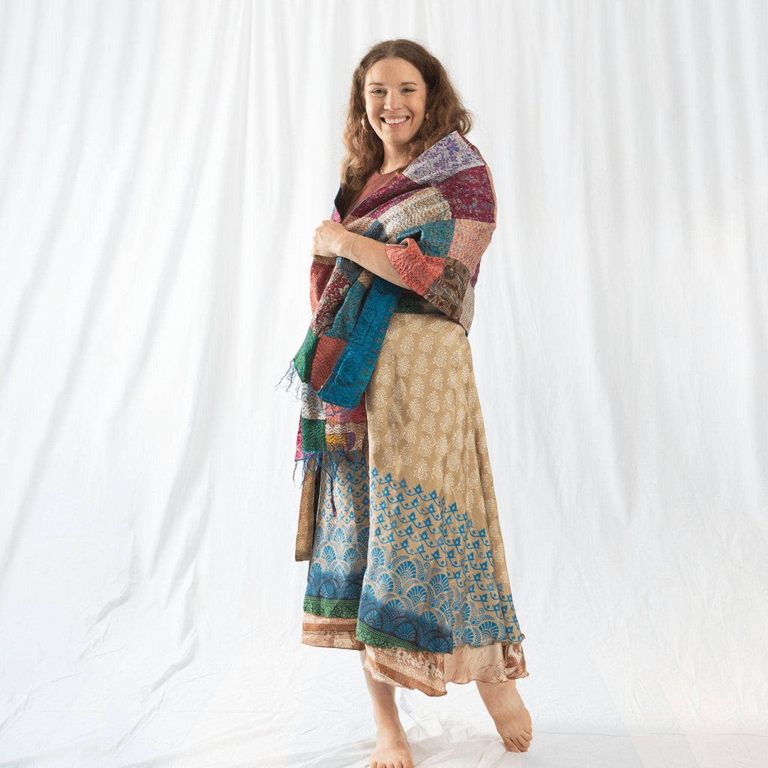 Founder Nicole wrapped in neutral multicolored kantha scarf in front of a white background.