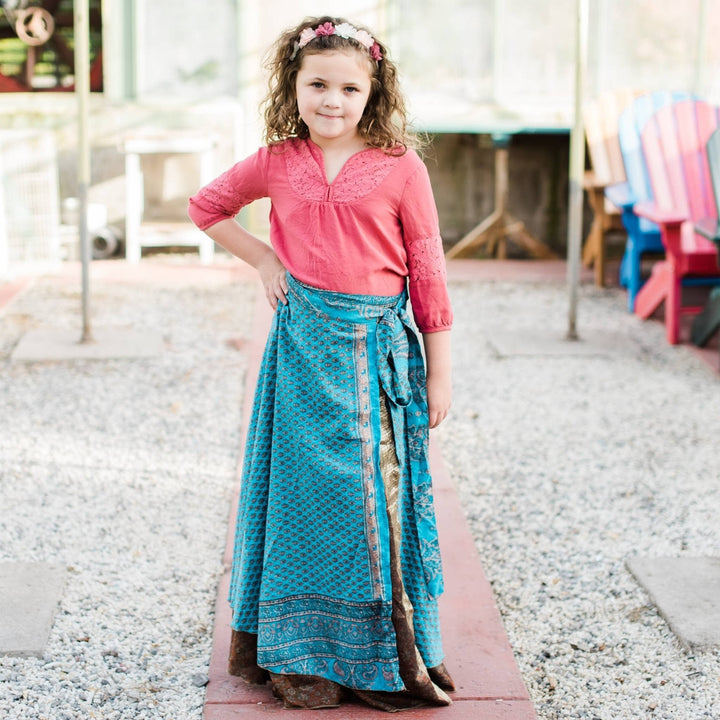 Kid model wearing a one of a kind long blue and brown sari wrap skirt. 