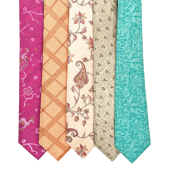 Lot of 5 one of a kind silk neck ties laying in a row in front of a white background. From left to right: pink with peacocks, orange with squares, neutral with paisly flowers, neutral with small darker spots, teal with darker blue plant prints.