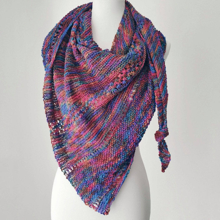 pink, purple , blue, brown knit shawl on a mannequin