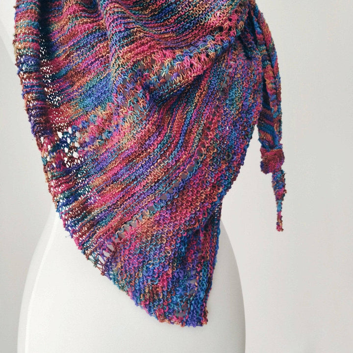 pink, purple , blue, brown knit shawl on a mannequin