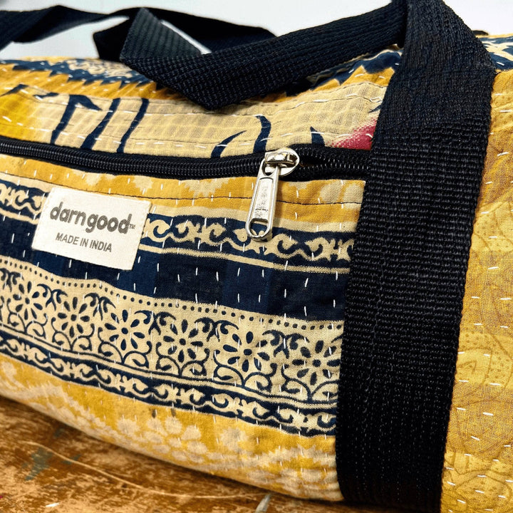 An up close shot of a handcrated kantha bag showing the unique kantha embroidery on the front of the bag, as well as the easy to open front pocket for storage.