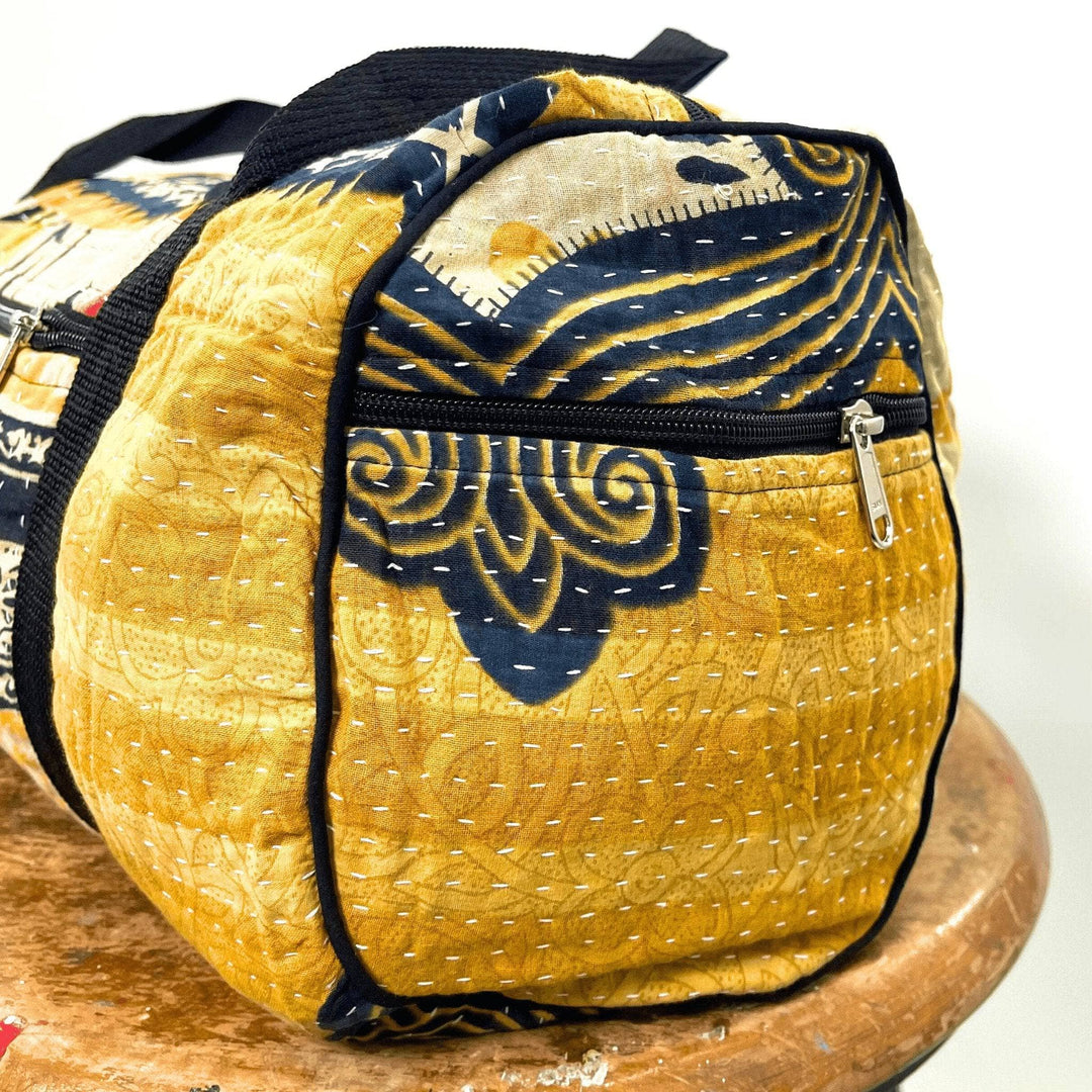 The side of a kantha stitched travel bag, showing the spacious side pocket of the travel bag as will as the delicate kantha stitching.