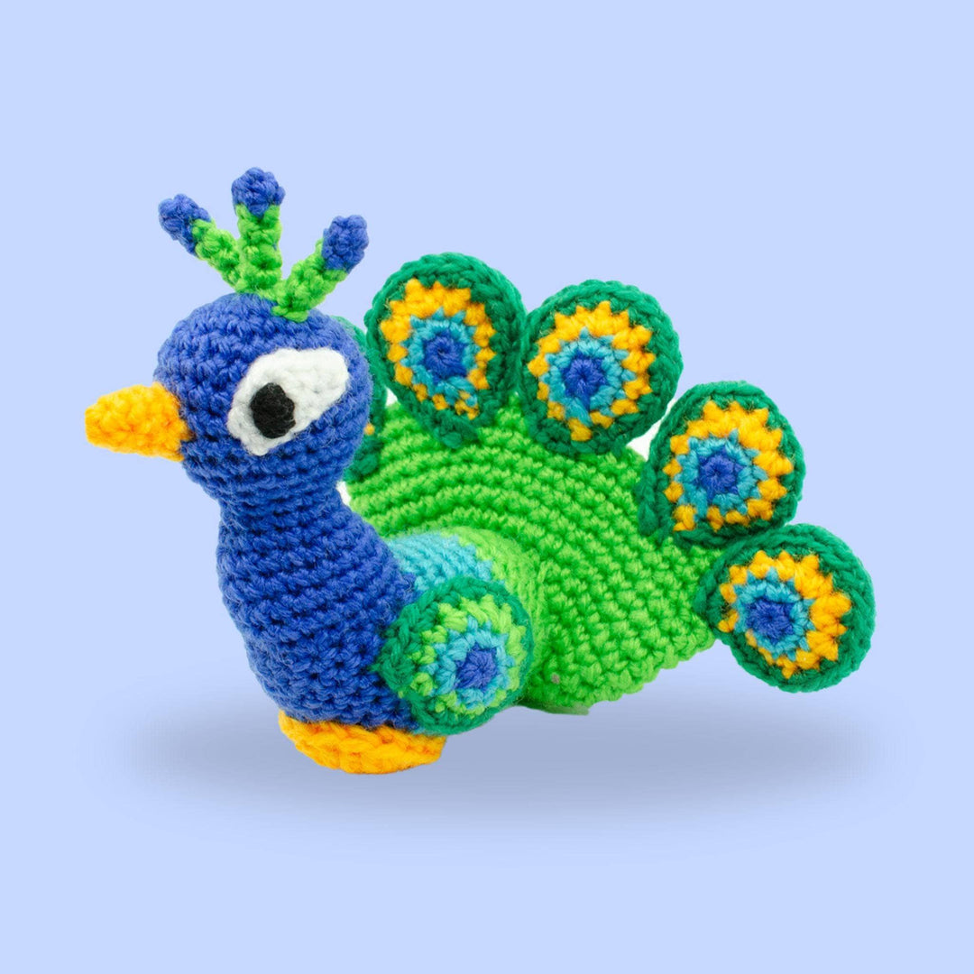 blue, green and yellow knit peacock amigurumi on a purple background