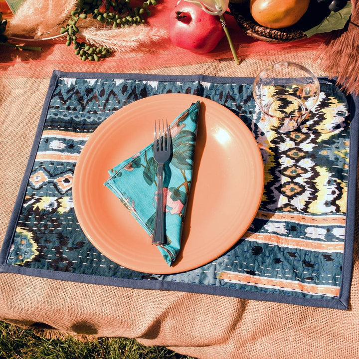 Ocean waves placemat on a table with an orange plate on top of it. 