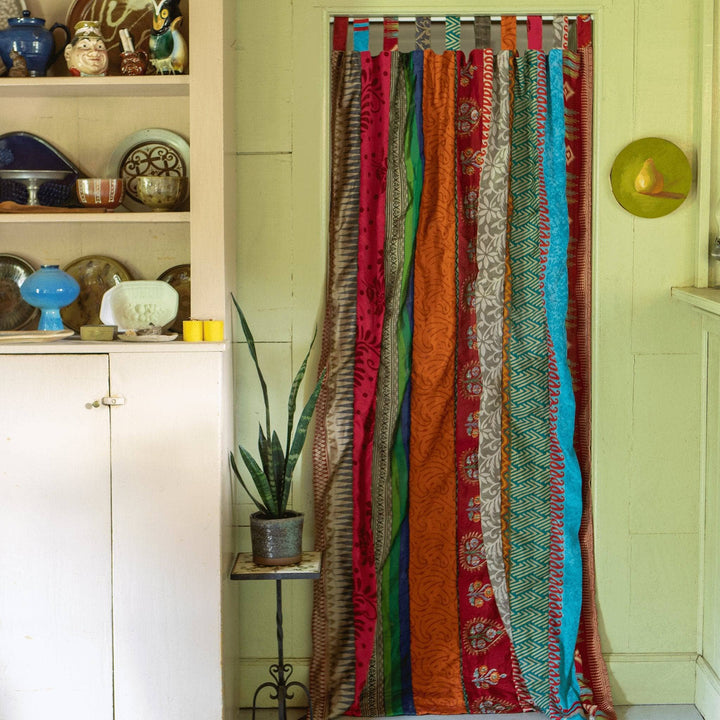 A one of a kind recycled sari drape hanging in a doorway