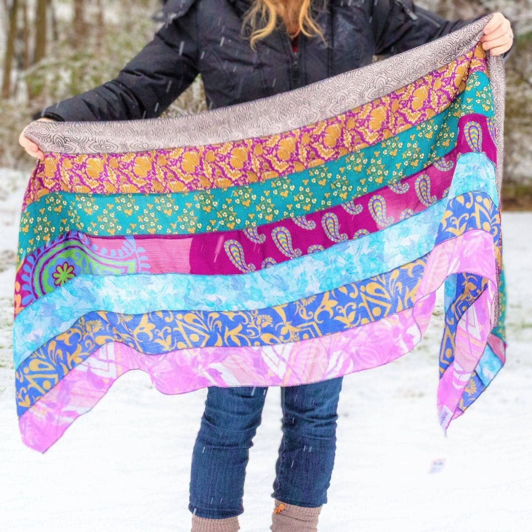Woman holding medley scarf to show all the layers of color and patterns