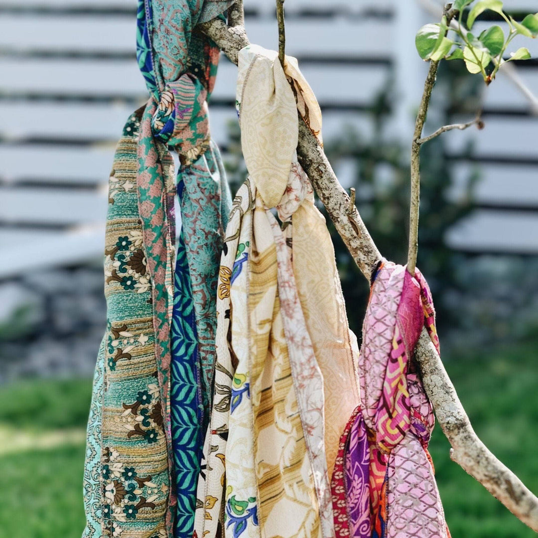 3 reclaimed sari medley scarves tied to a tree.