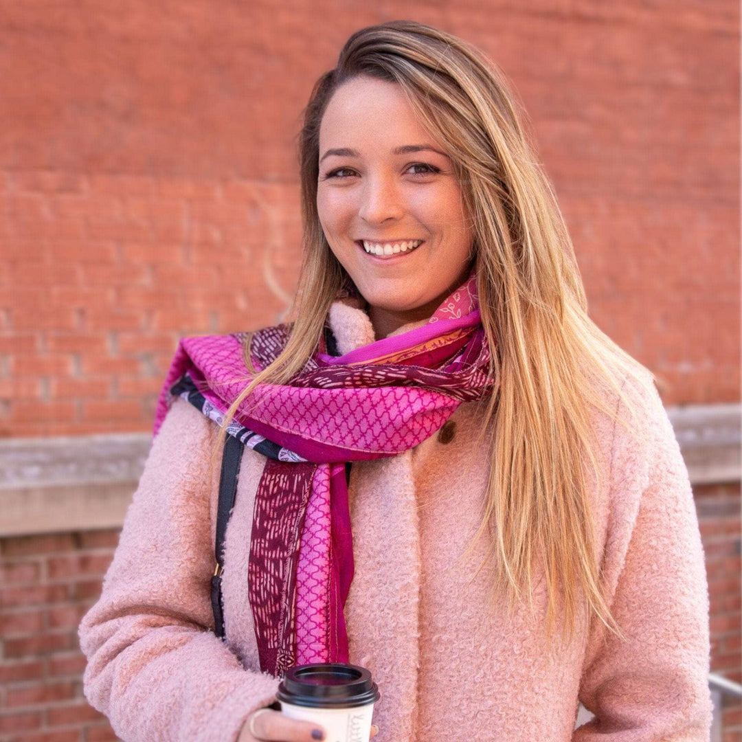 Woman holding a coffee wearing a medley scarf around her neck