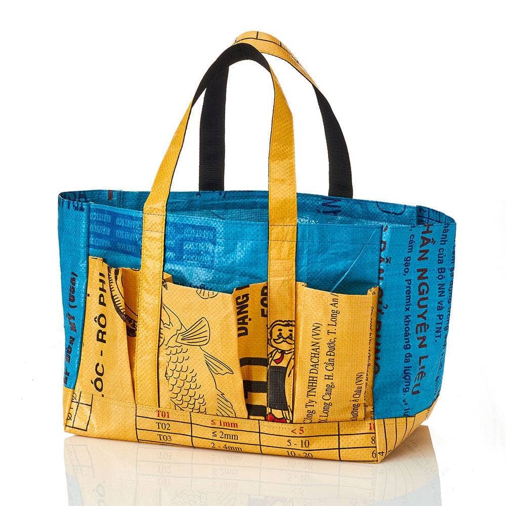 Recycled Feed Bag Gardening Tote in blue and yellow in front of a white background, showcasing three exterior pockets for added convenience.