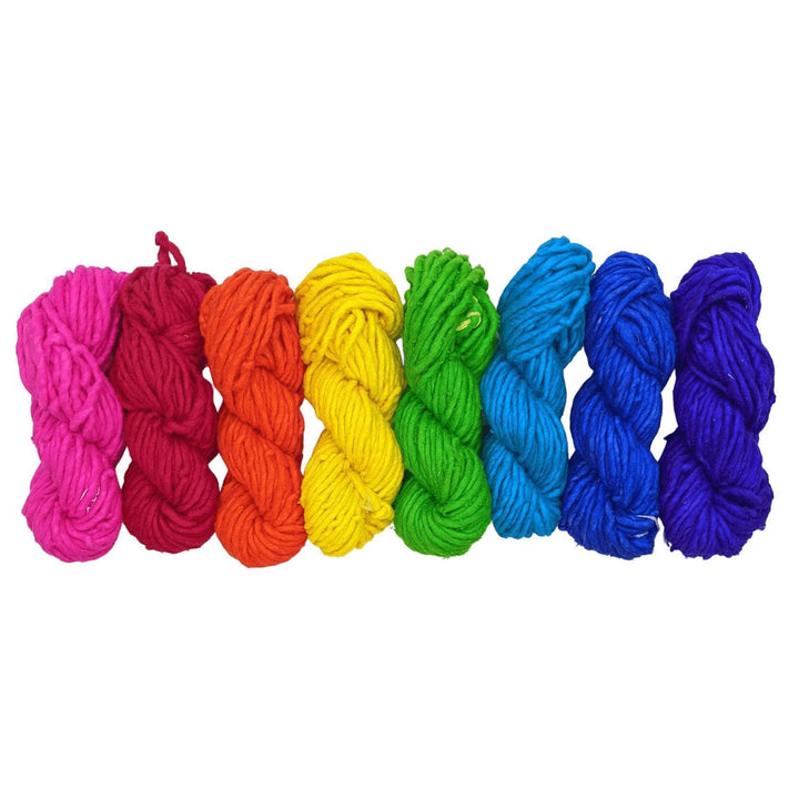 Mexicali dreams super bulky yarn bundle in rainbow order arranged in a line in front of a white background.