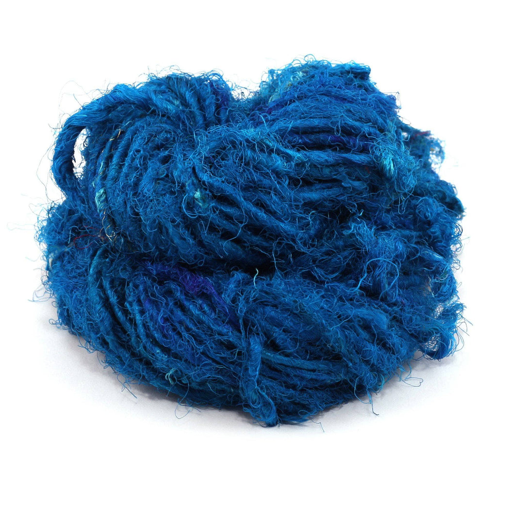  Recycled Silk Yarn close up in the color "Caribbean Ocean," a deep blue hue, with a white background