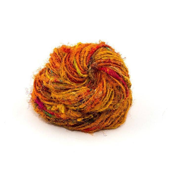  Recycled Silk Yarn close up in the color "Sunflower," a blend of muted oranges, red, and yellows, with a white background