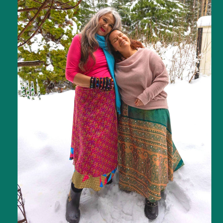 two women wearing sari wrap skirts in the snow