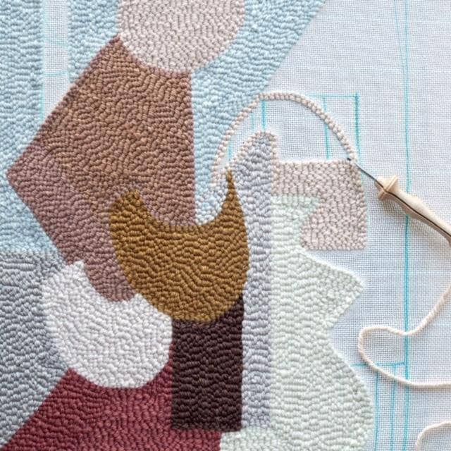 image of in progress punch needle project with punch needle still attached and some white aida canvas showing.