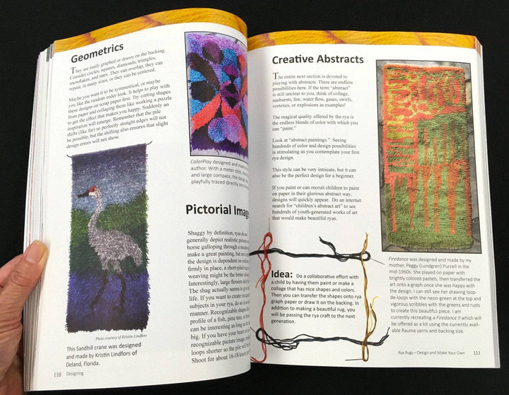 Rya Rugs Book opened to page 110-111. Page 110 Features the heading "Geometrics" and some text along with a photo of a geometric blue purple and orange rug. Below the photo is the Heading titled "Pictorial Images" accompanied by text and a photograph of a Rya wall hanging that displays a grey and black bird with a red head standing in a blue river in front of green landscape and grey-blue sky.