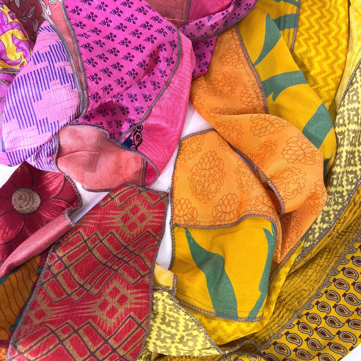 close up on warm toned sari silk medley scarves. 