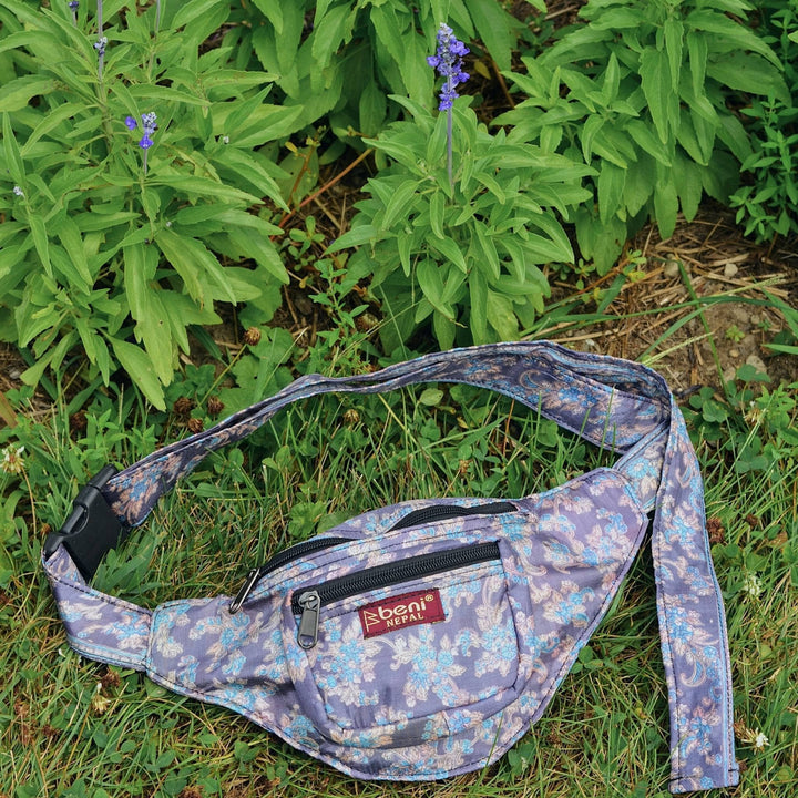 Purple sari silk fanny pack laying in the grass. 