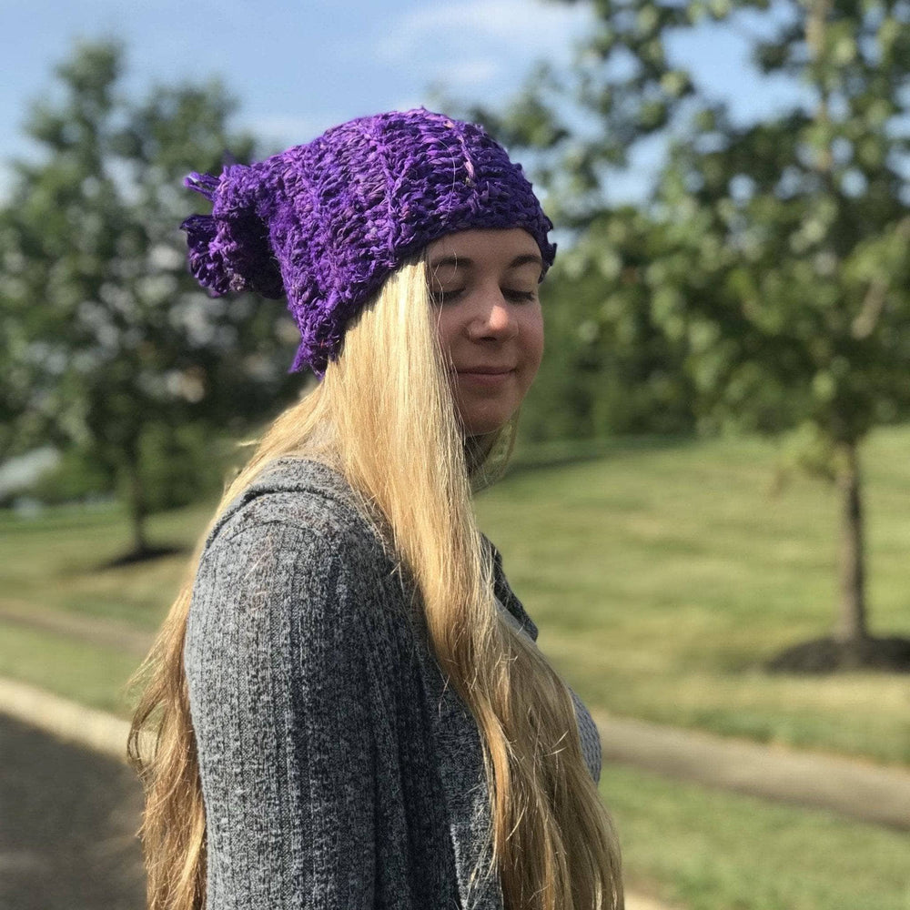 Side view of a girl wearing a purple sari ribbon hat outside