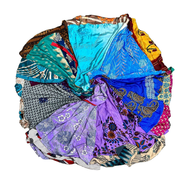 Color wheel made out of cool toned sari wrap skirts  on a white background. 