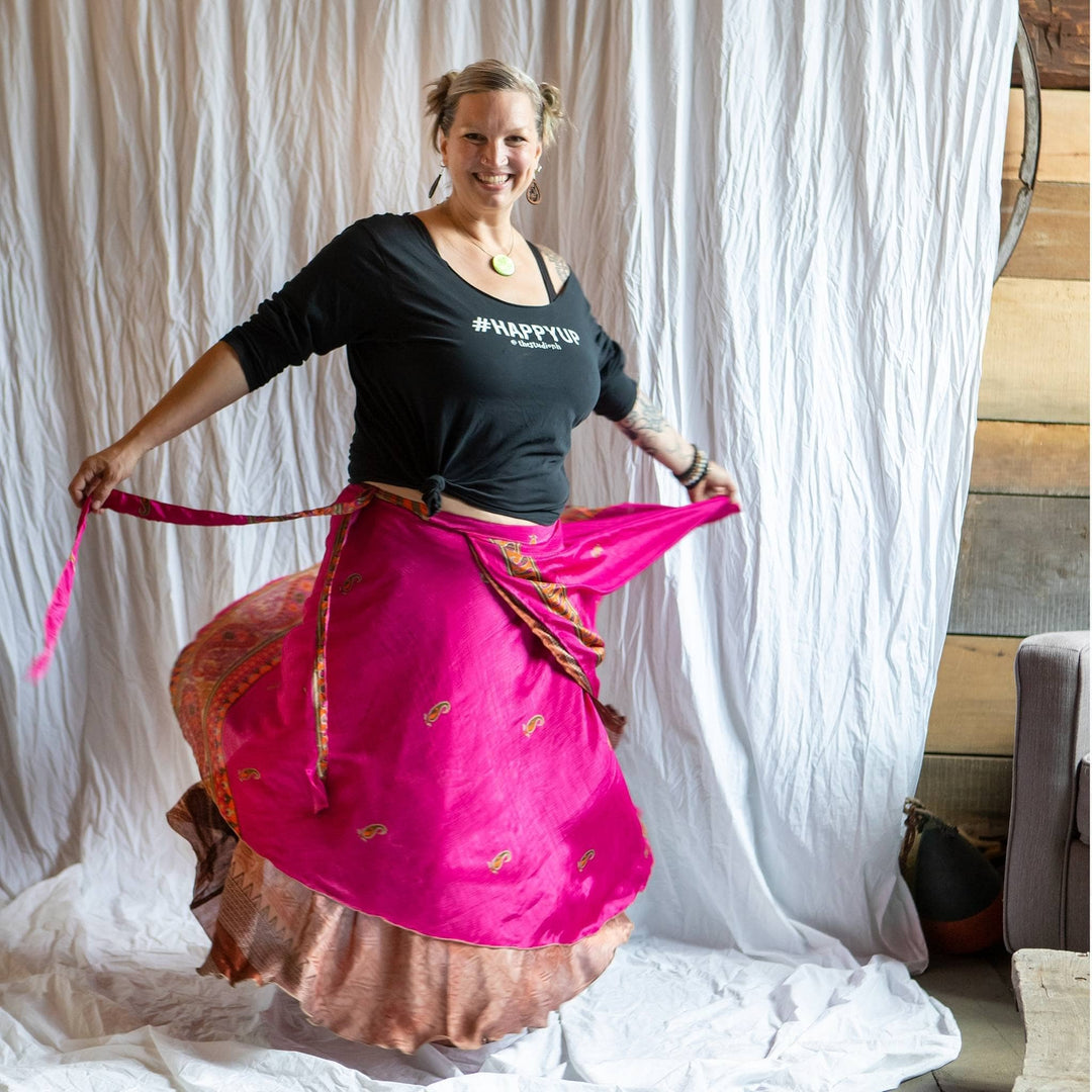 Model is spinning wearing a pink sari wrap skirt. 