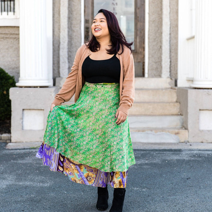 A woman wearing a green floral skirt with a colorful hem.