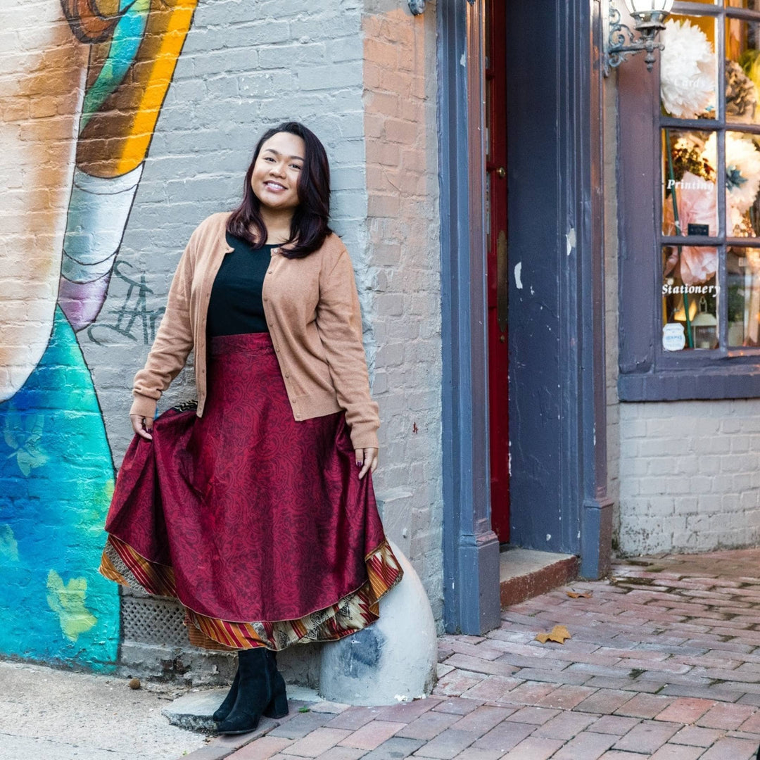 Model is outside in a city wearing a maxi length sari wrap skirt. 