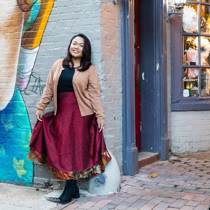 Model is outside in a city wearing a maxi length sari wrap skirt. 