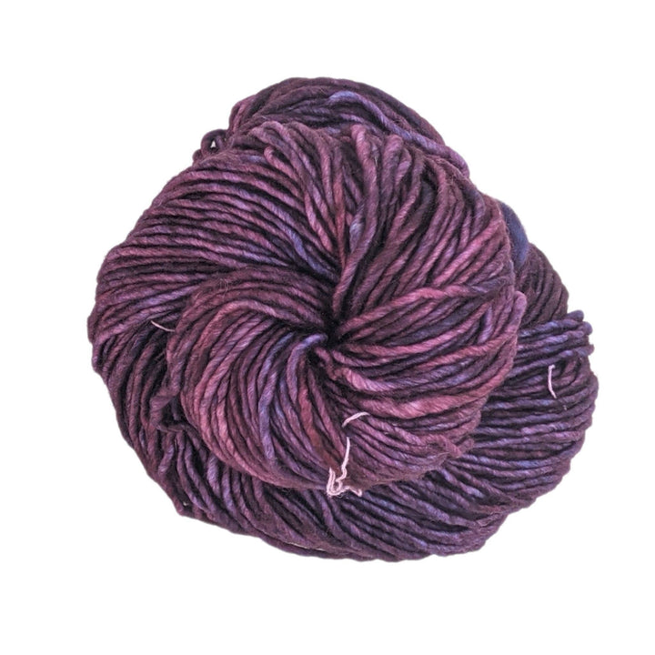 tonal purple yarn in front fo a white background.