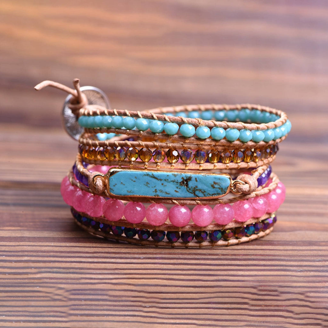 Turquoise and Pink Beaded Wrap Bracelet sitting on a wooden table 