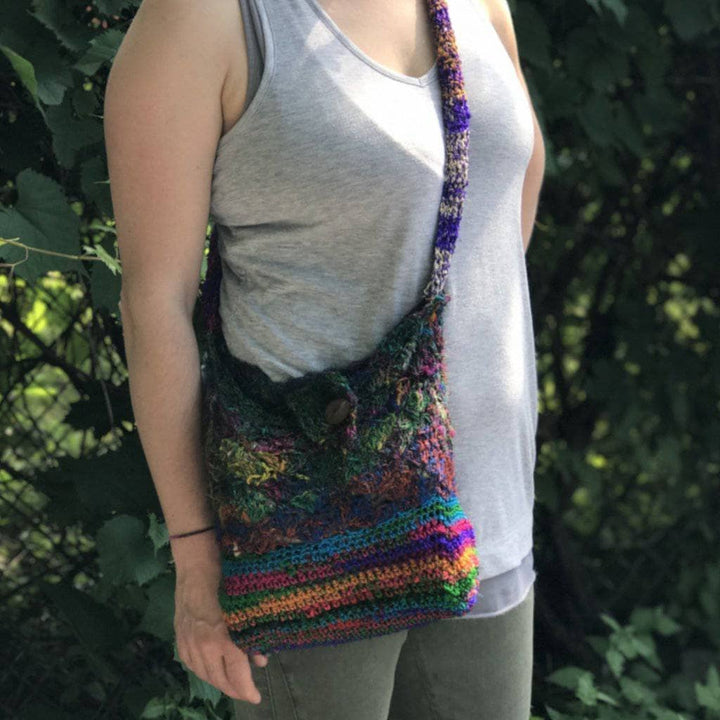 A woman outside with a multicolored cross body purse on