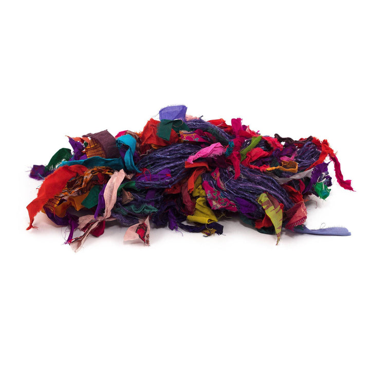 A purple skein of banana fiber yarn with multicolored ribbons tied to it on a white background