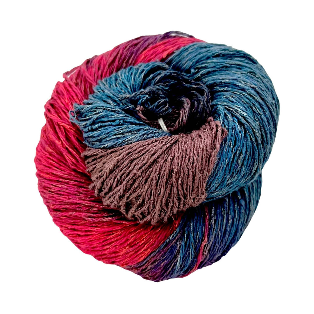Variegated red, brown and blue skein of silk blend sport weight eighty-twenty rule yarn on a white background