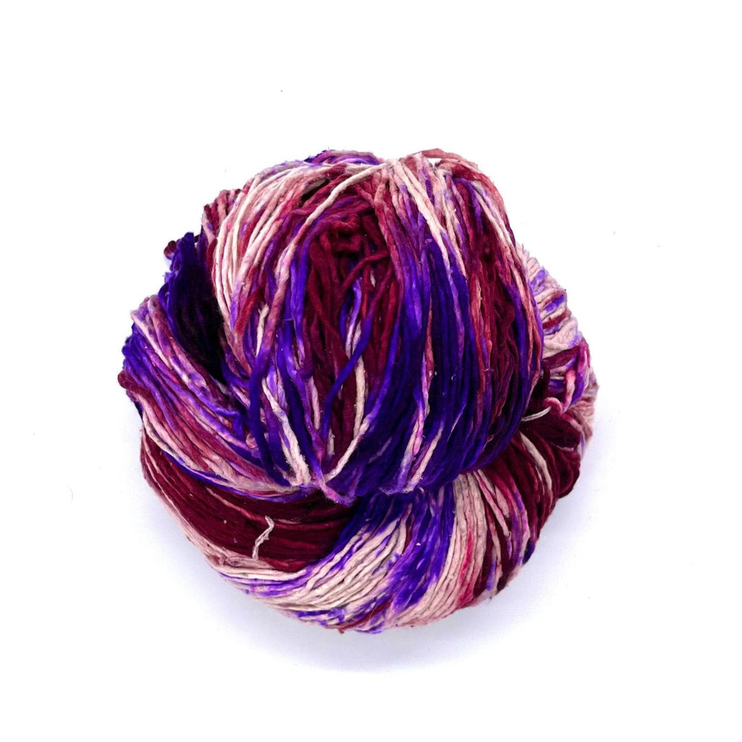 Maroon, Violet, Purple, Lilac, and white worsted weight yarn on a white background