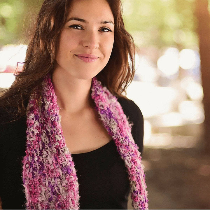 woman wearing a Simple Tunisian Crochet Scarf and smiling outdoors