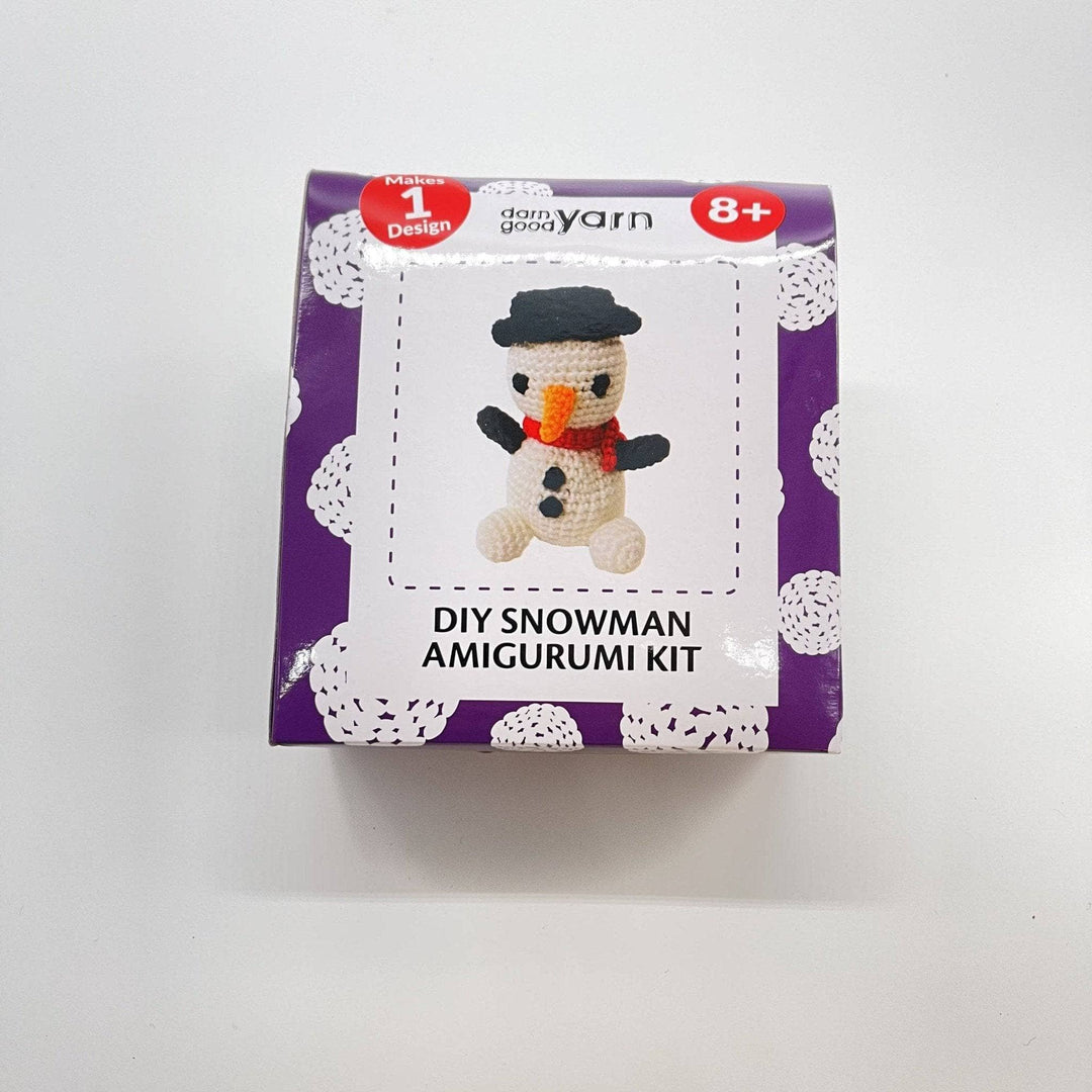 DIY Snowman Amigurumi Knit & Crochet Kit purple box on a whit bacdrop.