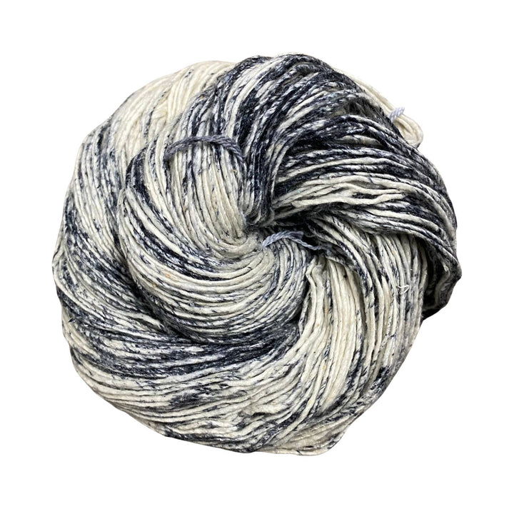 A skein of sport weight silk yarn in un-dyed (white) with black and charcoal section on a white background