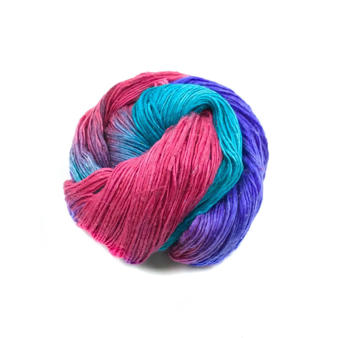 Sport weight silk yarn in Popsicle (pink, purple and turquoise) in front of white background.