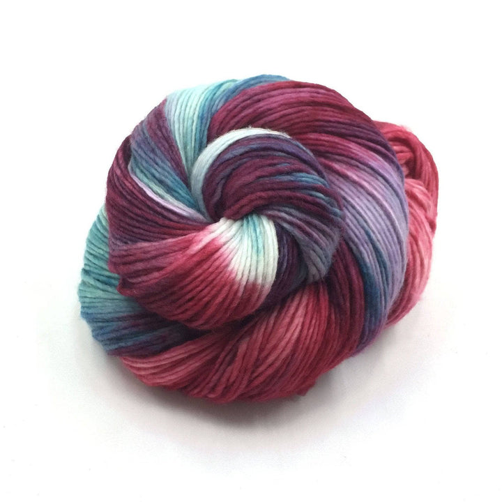 Worsted Weight Merino Wool Yarn donut ball in Benjamin (pink and gray) on a white background